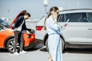 Woman calling with phone after the car collision