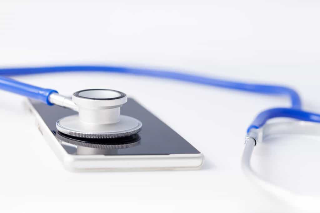 Smartphone being diagnosed by stethoscope - phone repair and check up concept